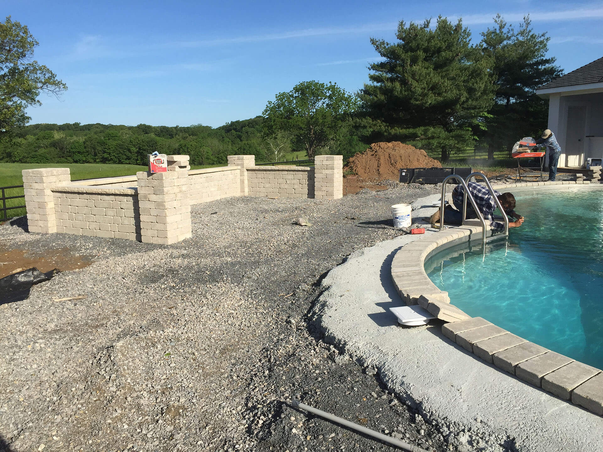 workers begin the installation of a stone pool deck in Jackson, MO Project