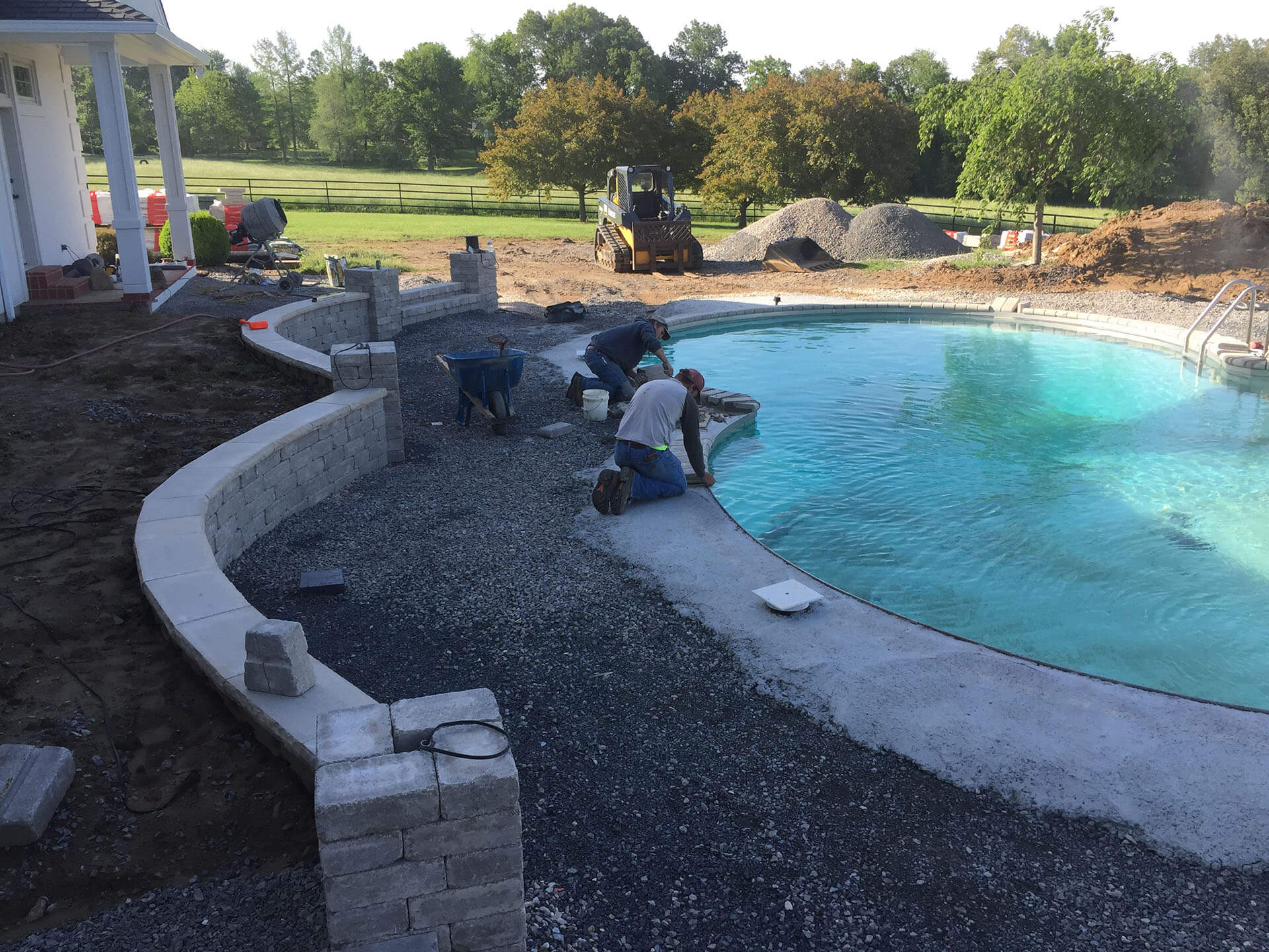 workers prepare the ground surface for he installation of a stone pool deck in Jackson, MO Project