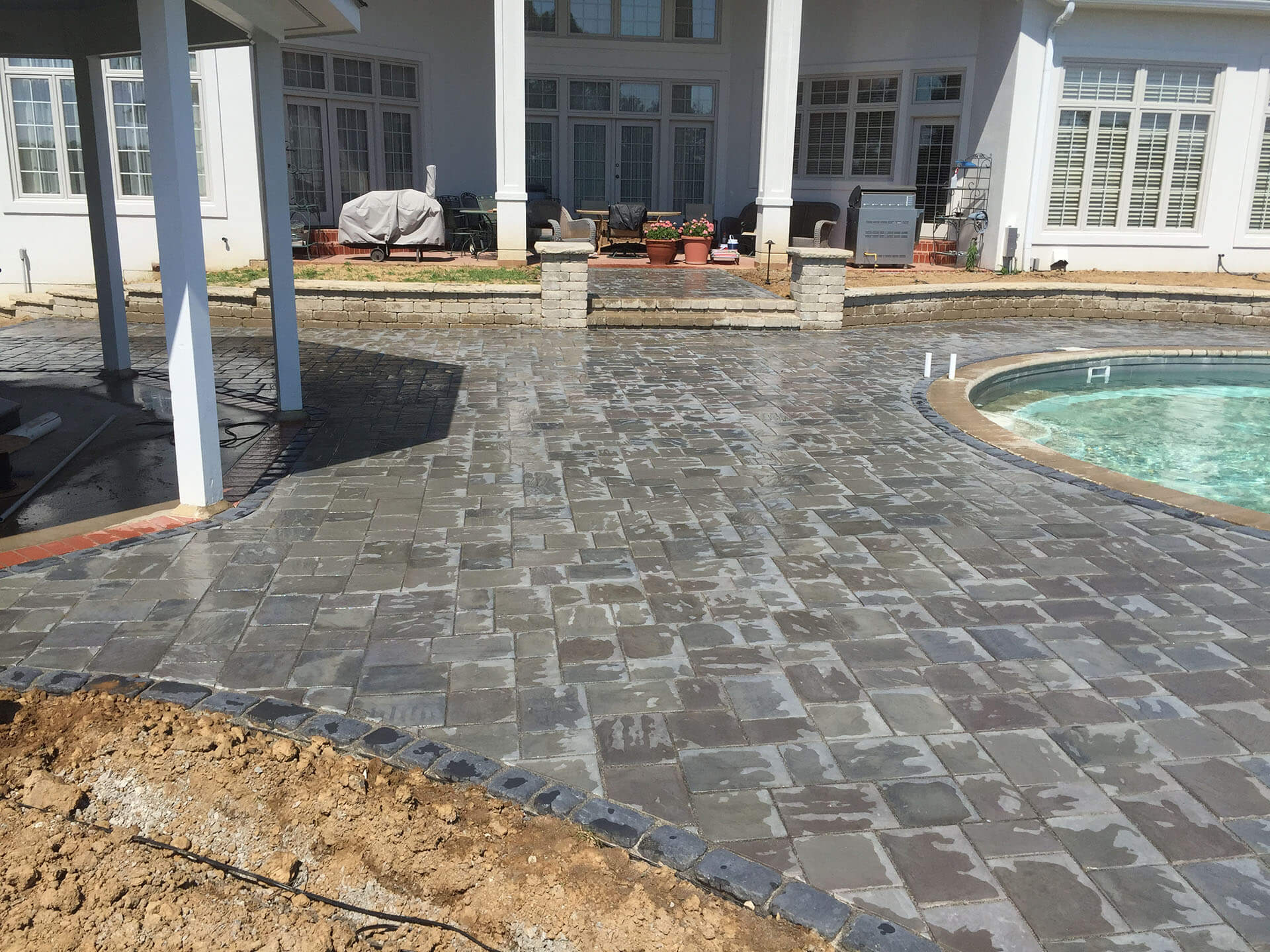 a custom stone pool deck nears completion at a home in Jackson, MO Project