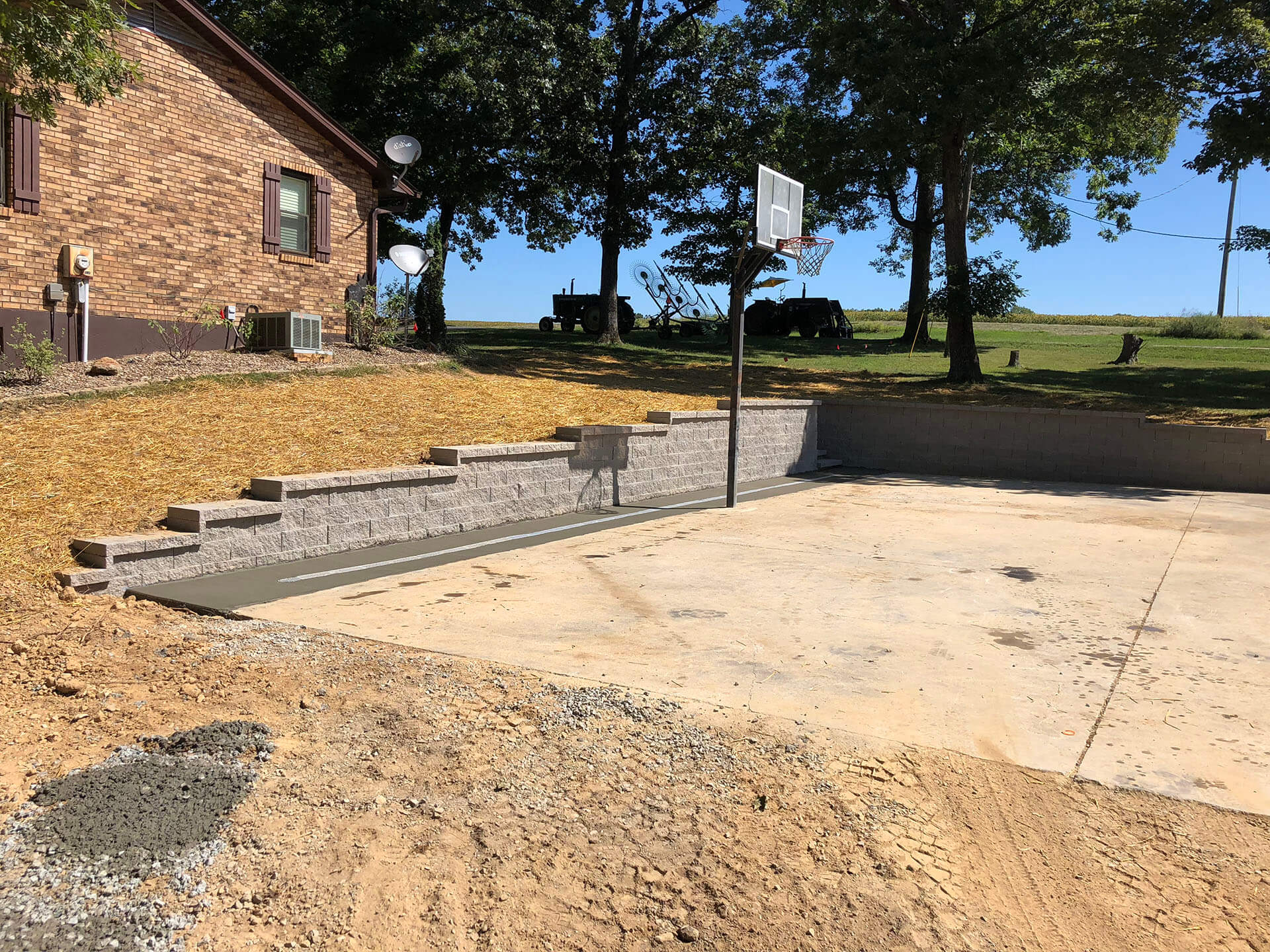 basketball court and integrated stone retaining wall for a home in Leopold, MO Project