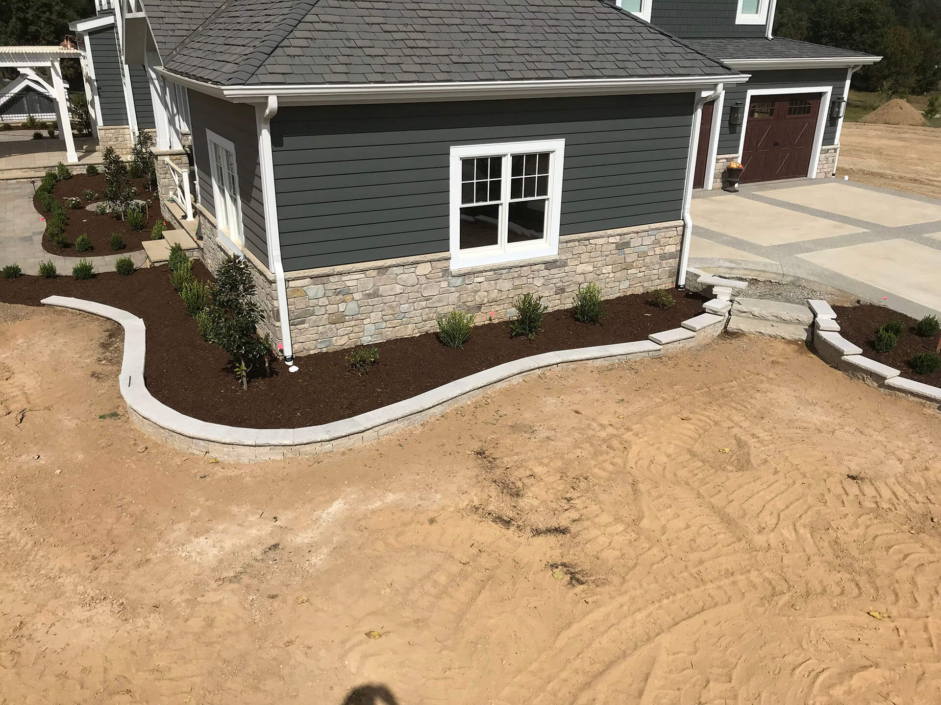 low stone retaining walls with white cap stones Dexter, MO Project