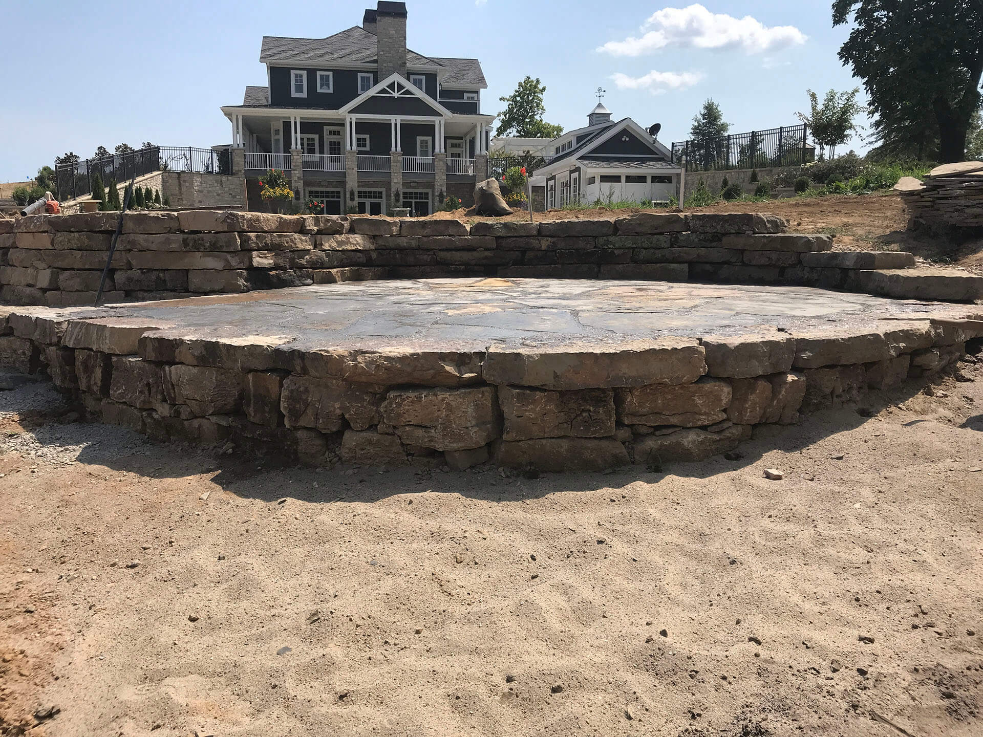 natural stone patio is raised above the lawn Dexter, MO Project