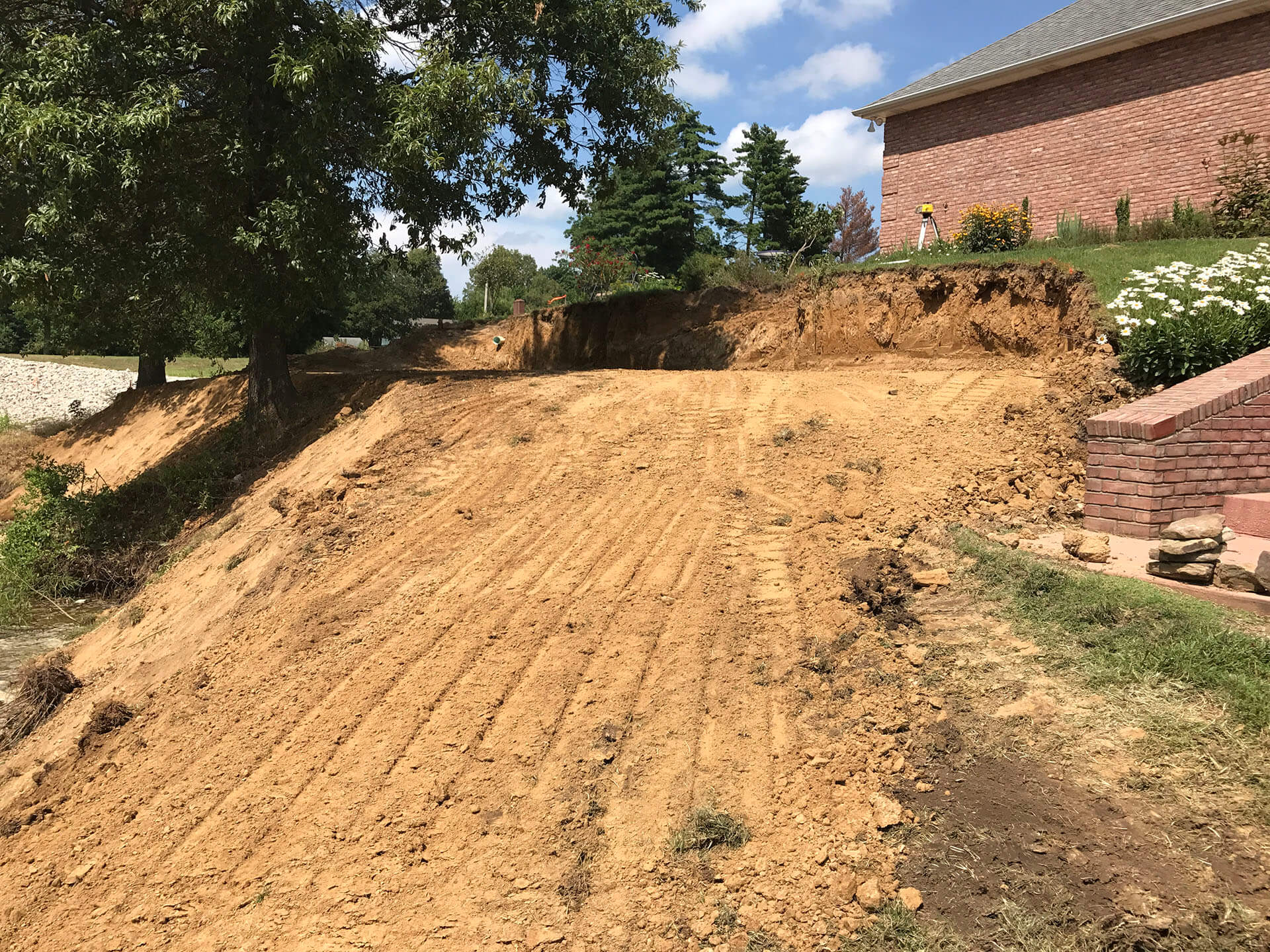 ground is leveled and prepared ahead of the construction of a retaining wall in the ayrd of a home in Dexter, MO Project
